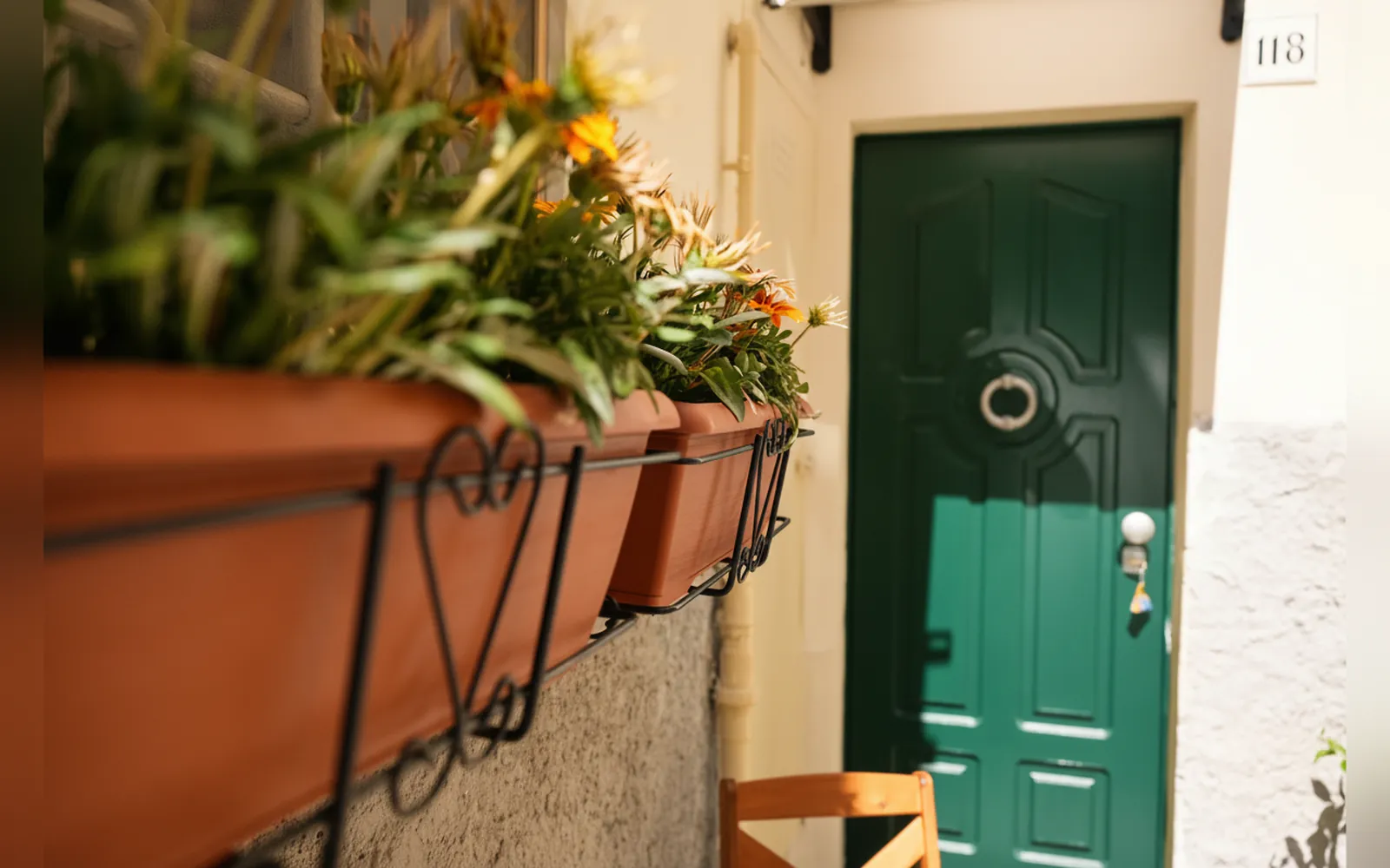 La porta d’ingresso verde con le fioriere